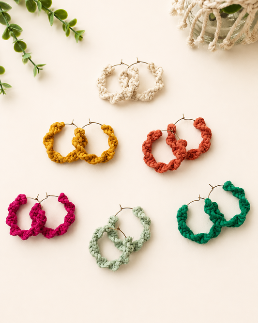 Handmade macramé hoop earrings in mustard, terracotta, off-white, fuchsia pink and mint green on a neutral fabric background