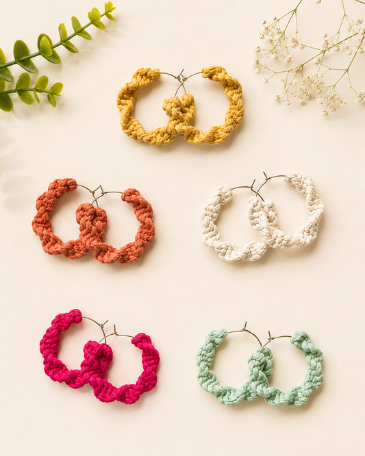 Handmade macramé hoop earrings in mustard, terracotta, off-white, fuchsia pink and mint green on a neutral fabric background