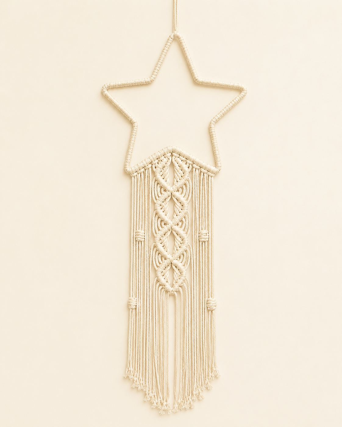 Macrame star wall hanging handmade with cotton cord and decorative fringe in off white boho nursery decor style