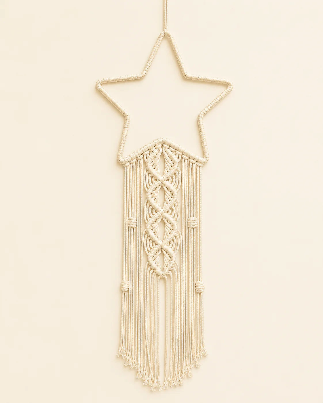 Handmade macrame star wall hanging with intricate knotwork and cotton fringe.