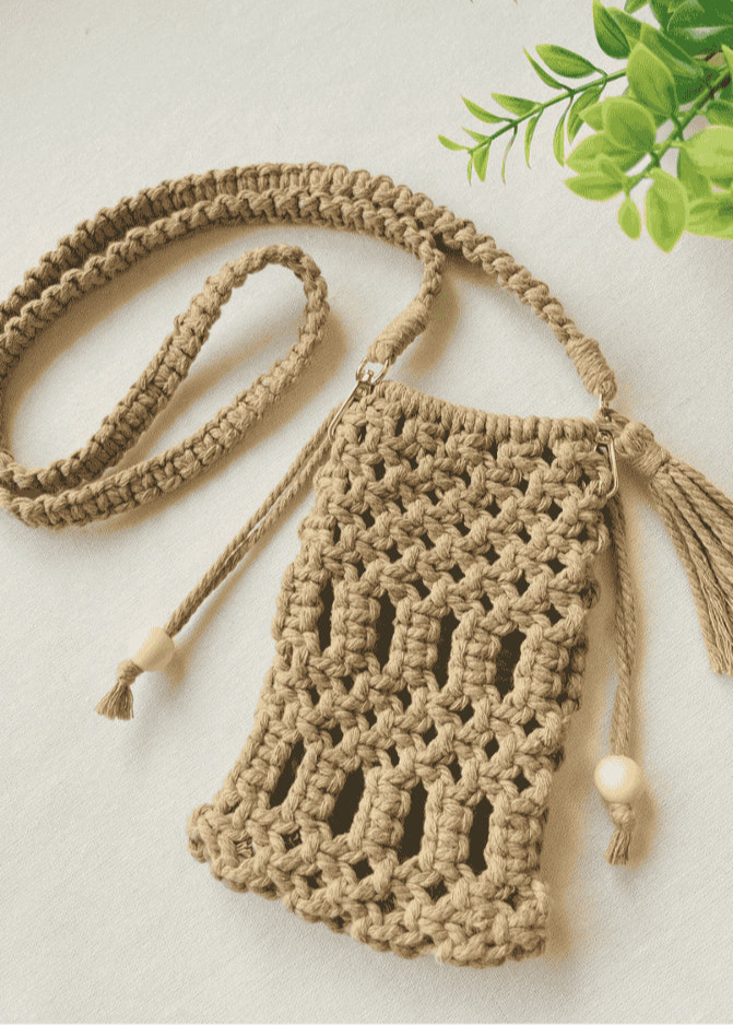 Full handmade macramé crossbody phone bag in light brown with boho-style strap and tassels