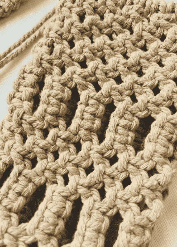 Close-up view of handmade macramé phone bag showing detailed knots in light brown cotton cord