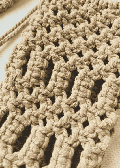 Close-up view of handmade macramé phone bag showing detailed knots in light brown cotton cord