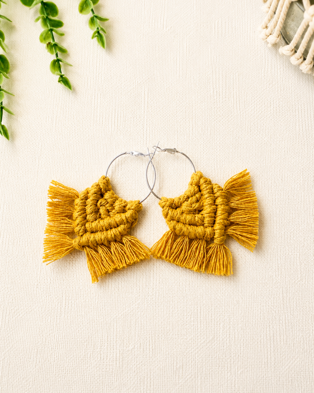 Handmade mustard yellow macrame chevron hoop earrings with silver hoops and cotton fringe.