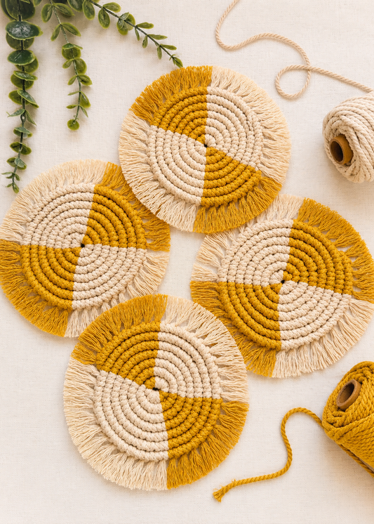 Set of round woven coasters with mustard and beige pattern on a light background