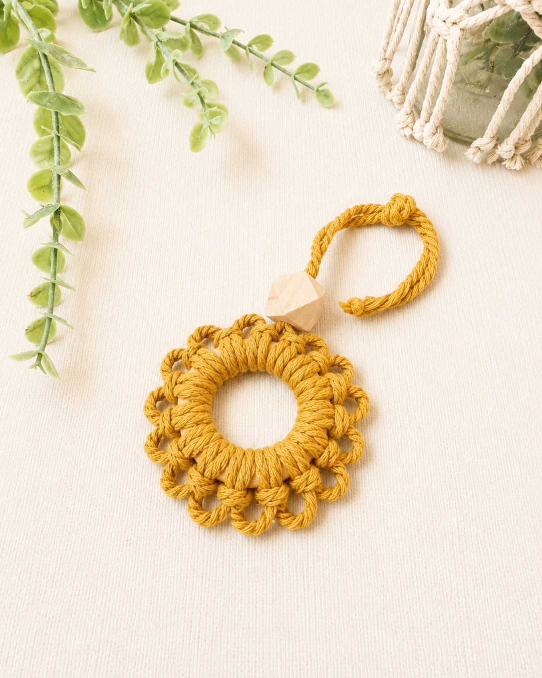 Handmade mustard macrame flower car diffuser with a natural wooden bead for essential oils and boho car décor.