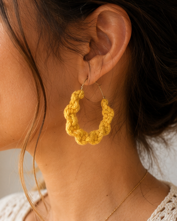 Close-up of a woman wearing handmade mustard macramé hoop earrings in a boho style