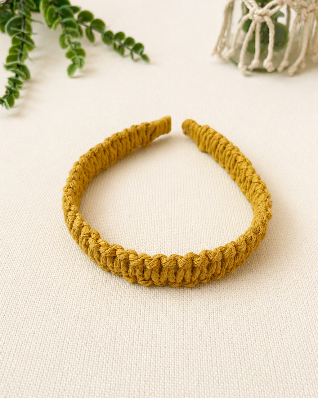 Handmade mustard macrame square knot headband with textured cotton cord design.