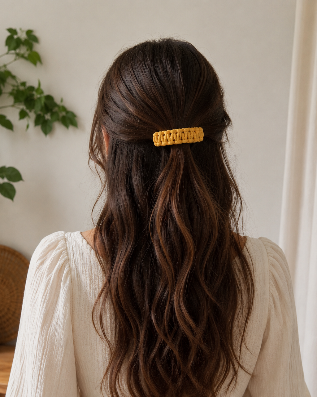 Back view of a woman wearing a handmade mustard macramé hair clip in a half-up hairstyle.