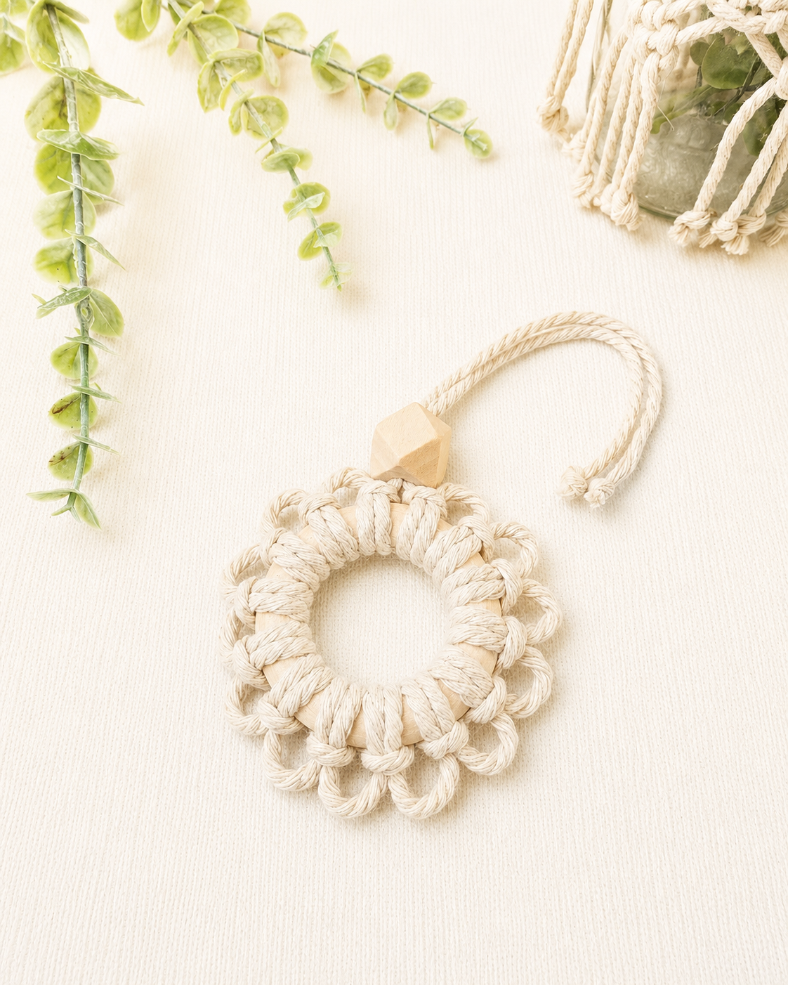 Handmade off white macrame flower car diffuser with a natural wooden bead for essential oils and car décor.