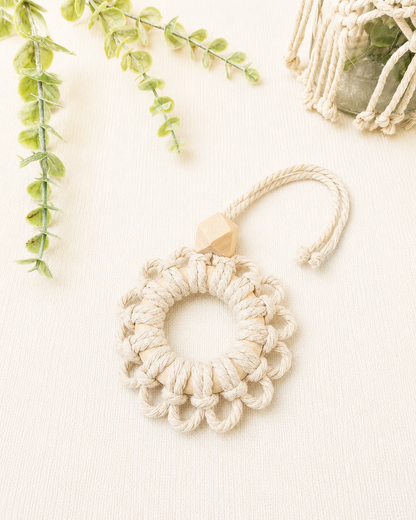 Handmade off white macrame flower car diffuser with a natural wooden bead for essential oils and car décor.