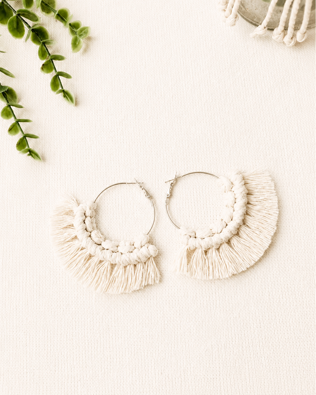 Handmade off white macrame fringe hoop earrings with stainless steel hoops.