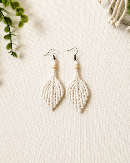 Handmade off white macrame leaf earrings with wooden bead detail and antique bronze hooks.