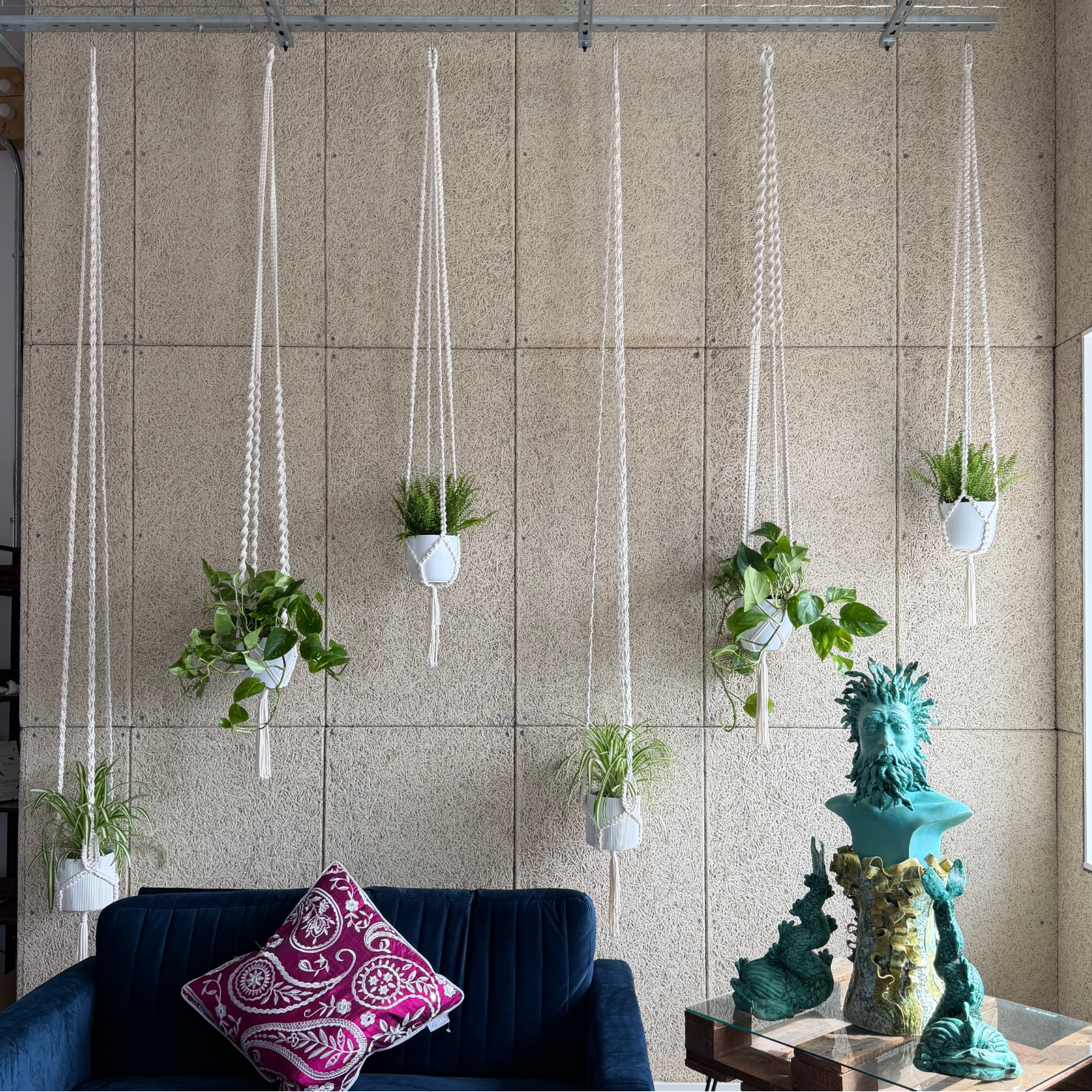 Oversized handmade macrame plant hangers displayed at different heights in the Harmonic Haven seating area