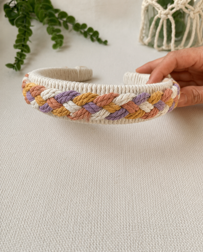 Close-up of a handmade pastel braided macrame headband with wrapped cotton base