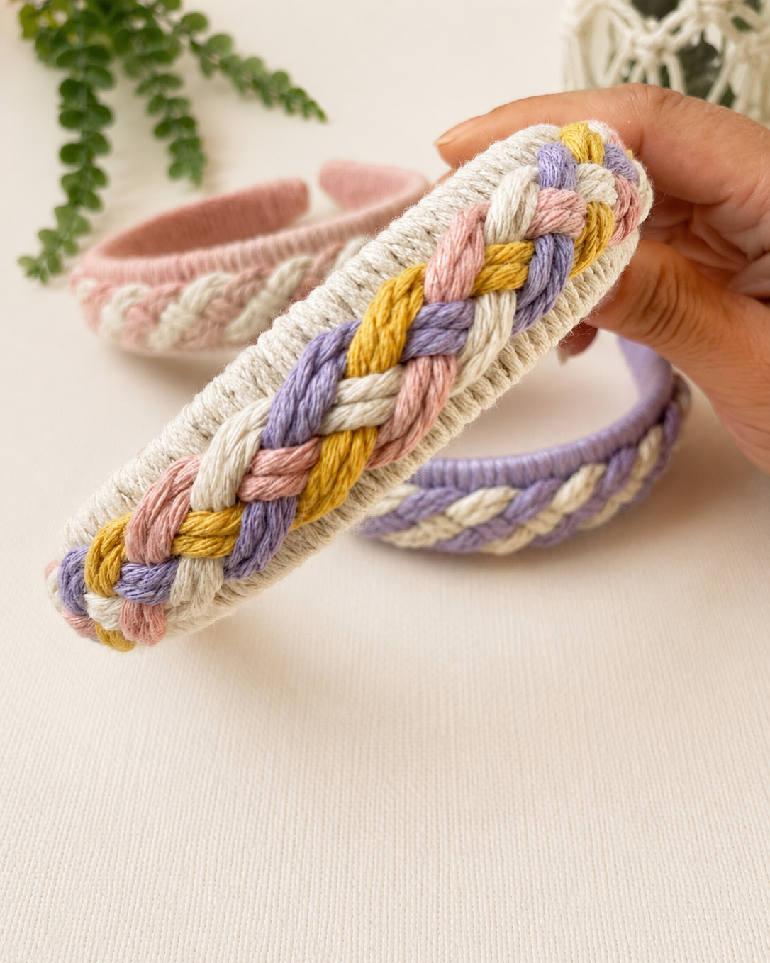 Close-up detail of a handmade pastel braided macrame headband