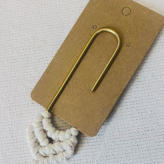 Handmade macrame heart bookmark displayed on its kraft backing card