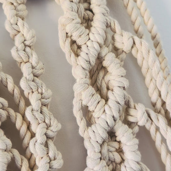 Video showing the handmade lotus macrame wall hanging from different angles, highlighting its detailed knotwork and natural cotton texture.