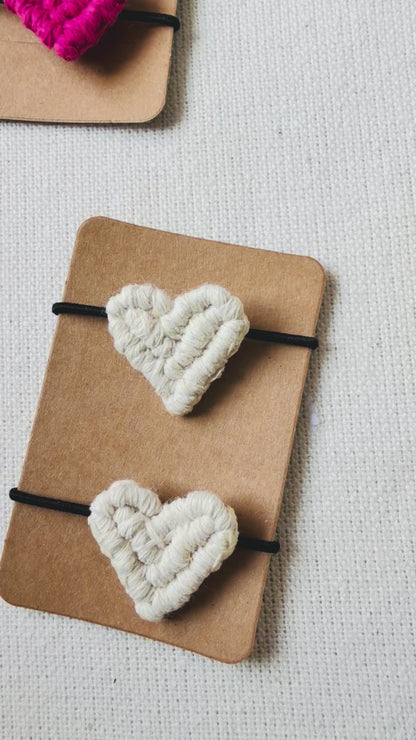 Video showing handmade macrame heart hair ties from different angles and close-up details.