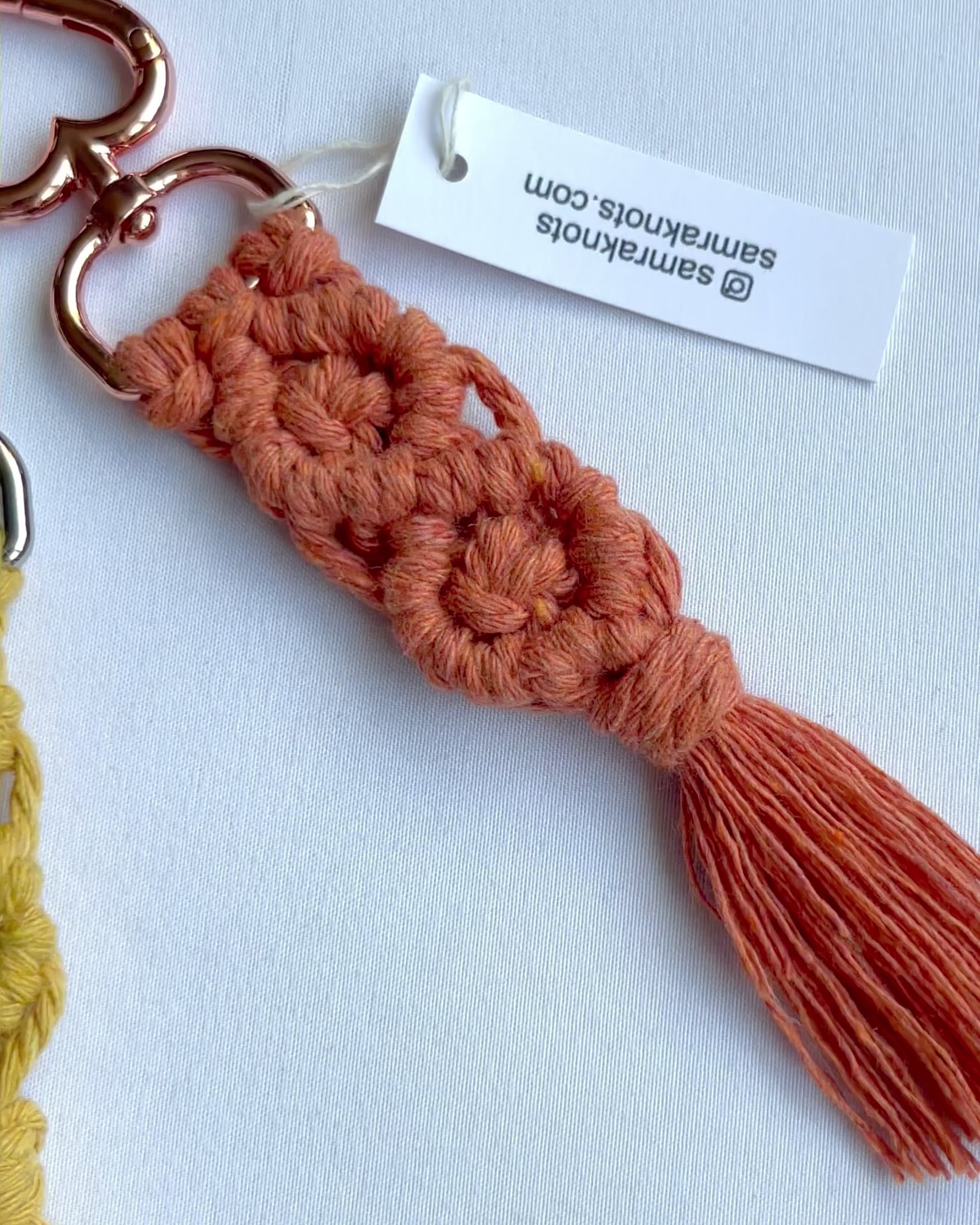 Video showcasing handmade macrame diamond keychains in multiple colours with tassels and metal clasps.