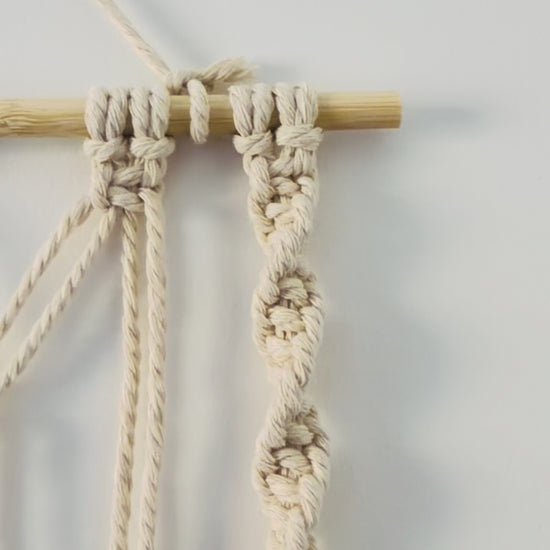 Handmade macrame photo holder with five leaves showing knot and cotton details.