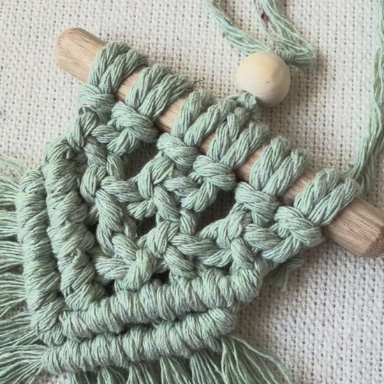Video showcasing boho macramé car charms in multiple colours including off white, mustard, mint green and light brown, handmade from cotton cord.