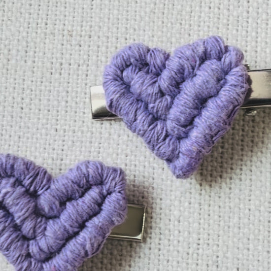 Video showing handmade macrame heart hair clips in natural, blush pink, lilac and fuchsia colours.