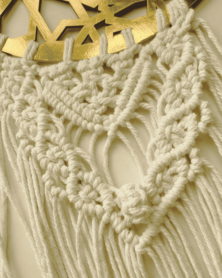Close-up of handmade macrame knotwork and gold Ramadan Kareem crescent wall hanging.