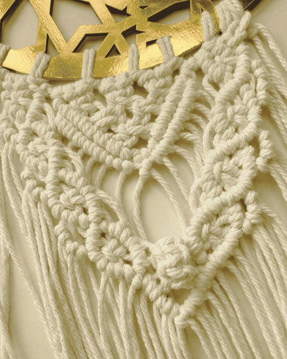 Close-up of handmade macrame knotwork and gold Ramadan Kareem crescent wall hanging.