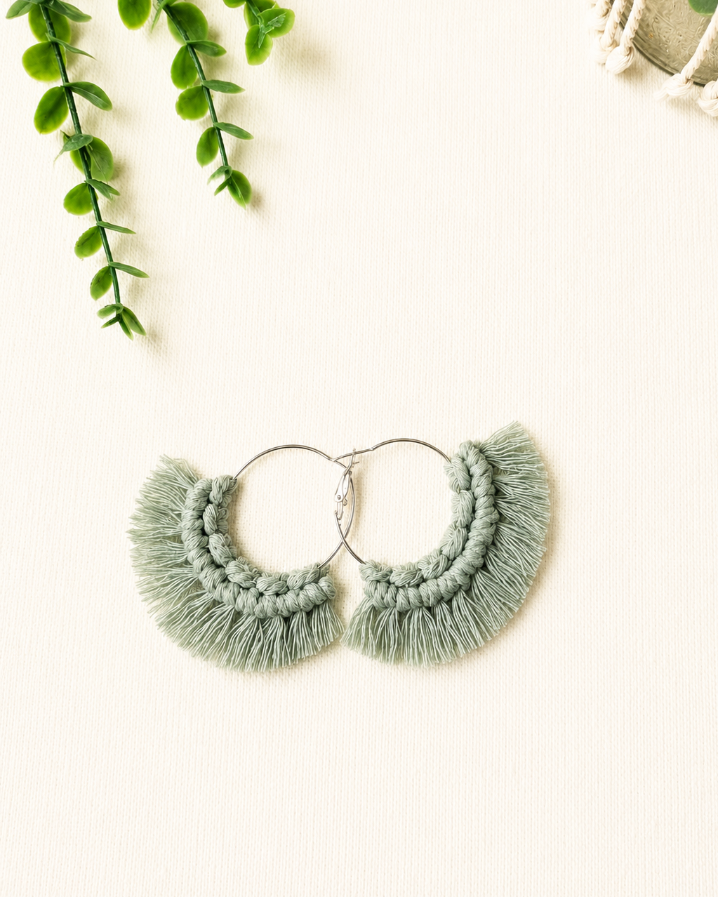 Handmade sage green macrame fringe hoop earrings with stainless steel hoops.