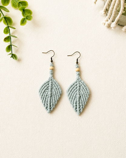 Handmade sage green macrame leaf earrings with wooden bead detail and antique bronze hooks.