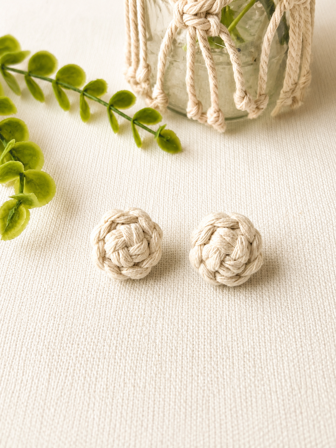 Off-white handmade macramé flower stud earrings crafted from cotton cord.