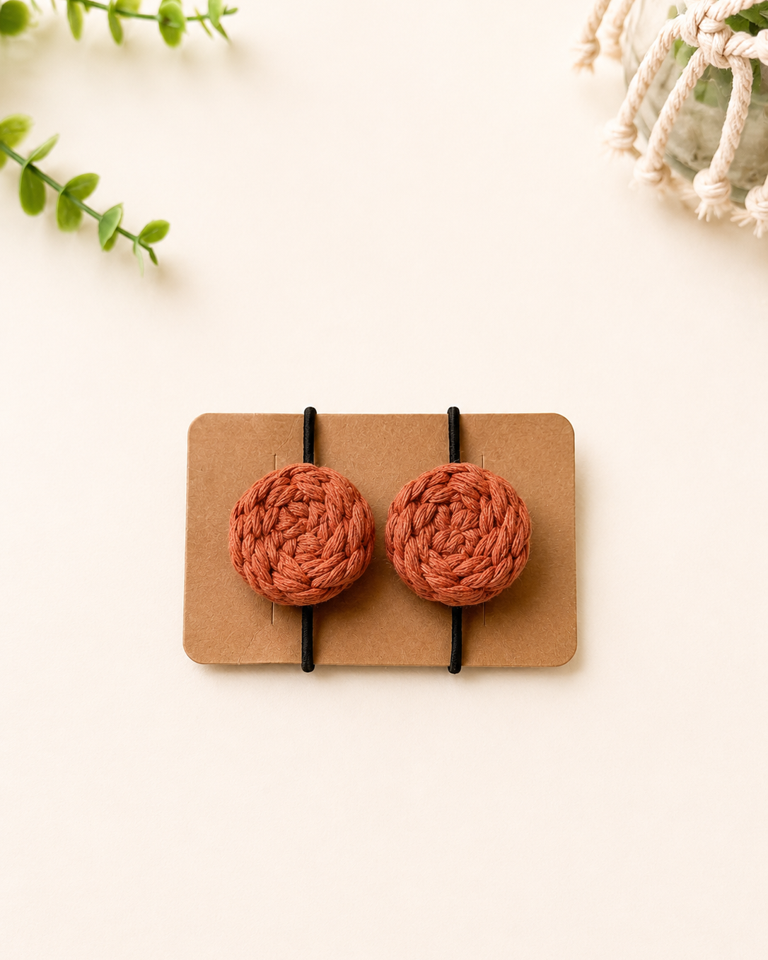 Terracotta handmade macrame cotton hair ties with black elastic bands.