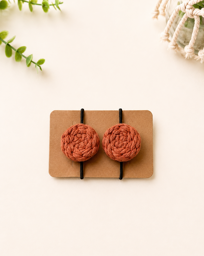 Terracotta handmade macrame cotton hair ties with black elastic bands.