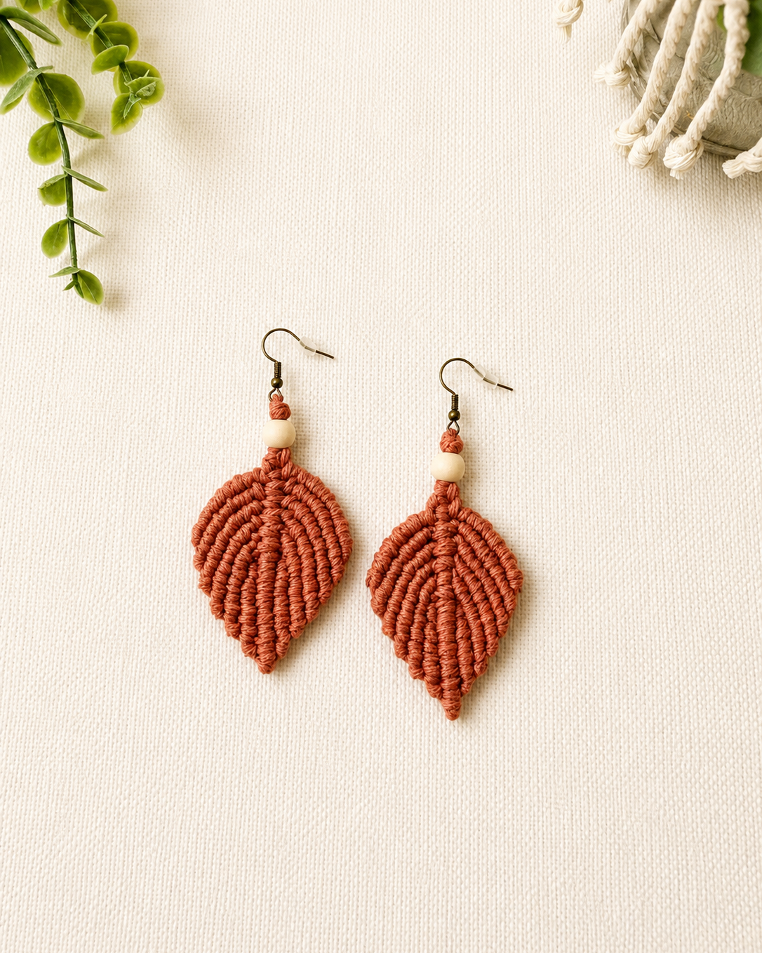 Handmade terracotta macrame leaf earrings with wooden bead detail and antique bronze hooks.