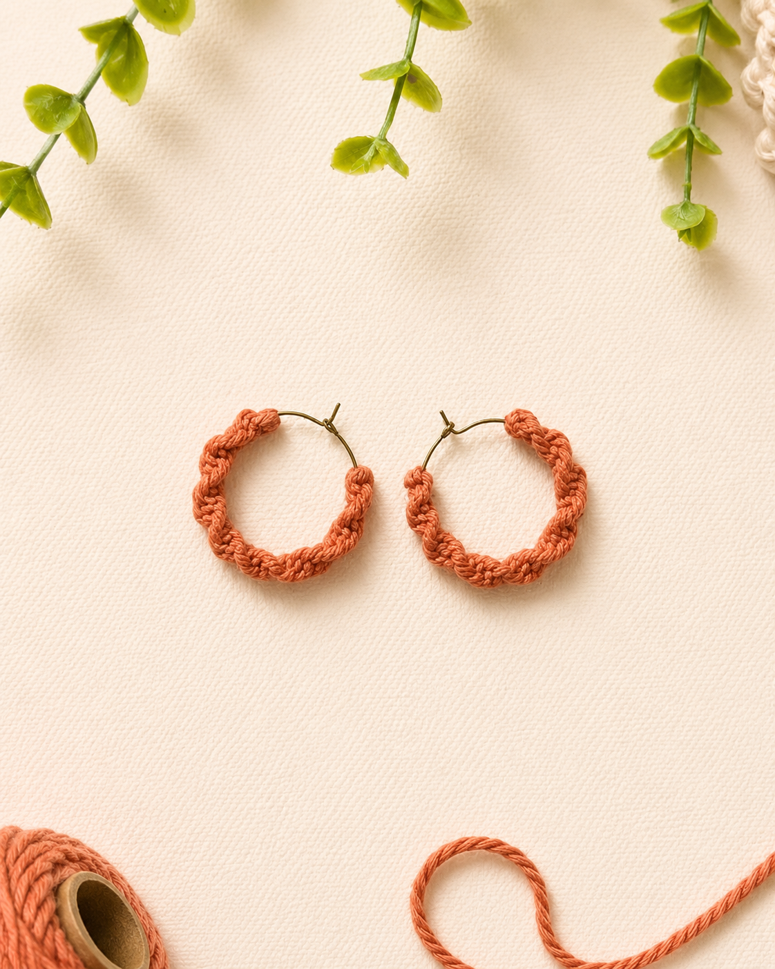 Terracotta handmade macramé spiral hoop earrings with textured spiral knot pattern.