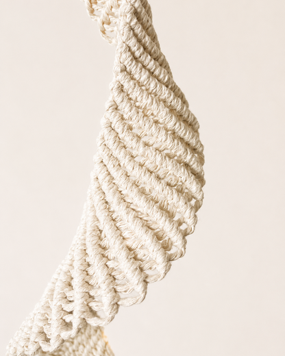 Close up of sculptural twisted macrame knot detail handmade with off white cotton cord