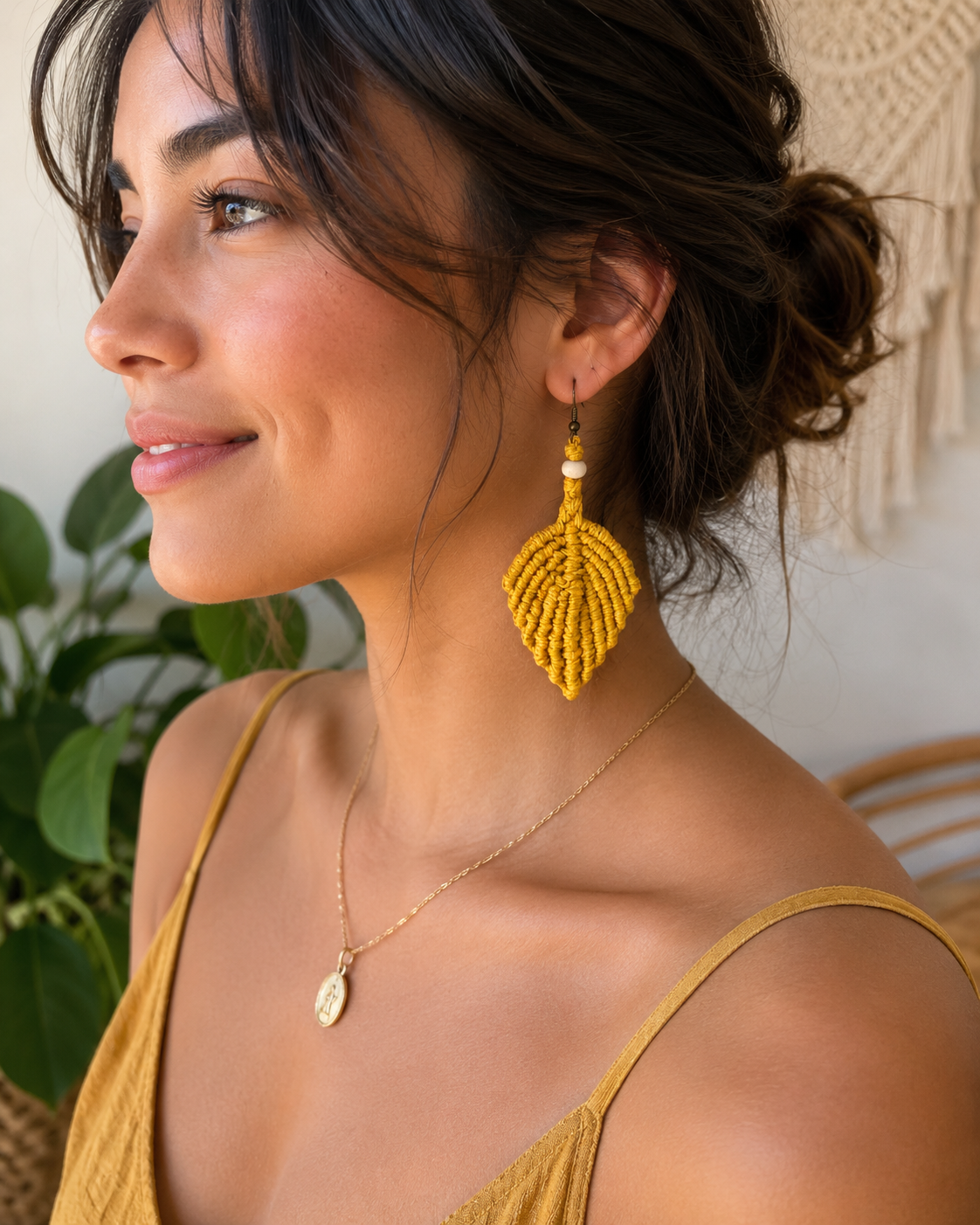 Woman wearing handmade mustard yellow macrame leaf earrings with wooden bead detail.