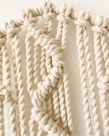 Close-up of handmade zigzag knot pattern on macrame star wall hanging